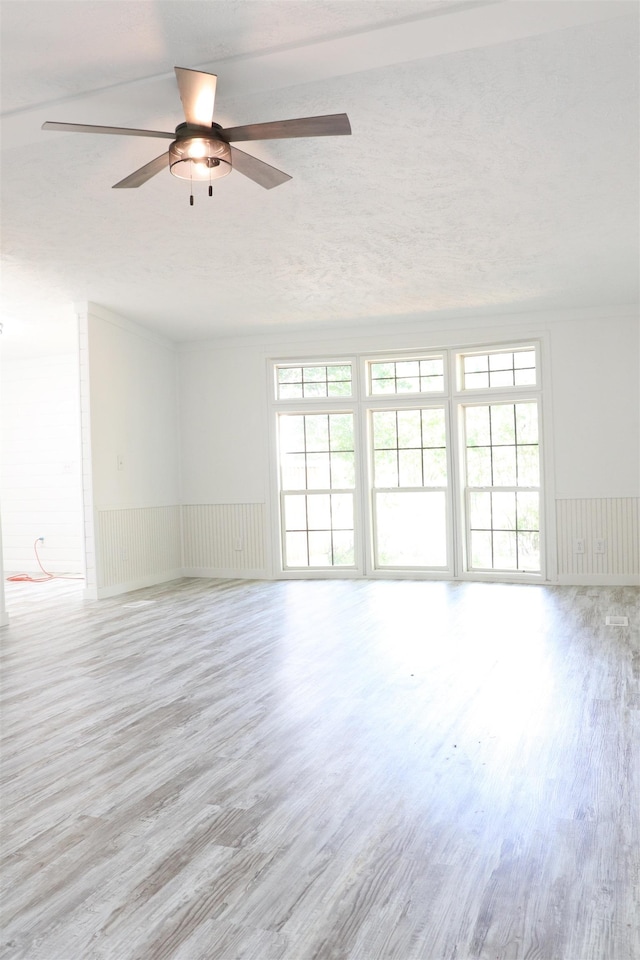  - unfurnished room featuring ceiling fan, plenty of natural light, and wood finished floors