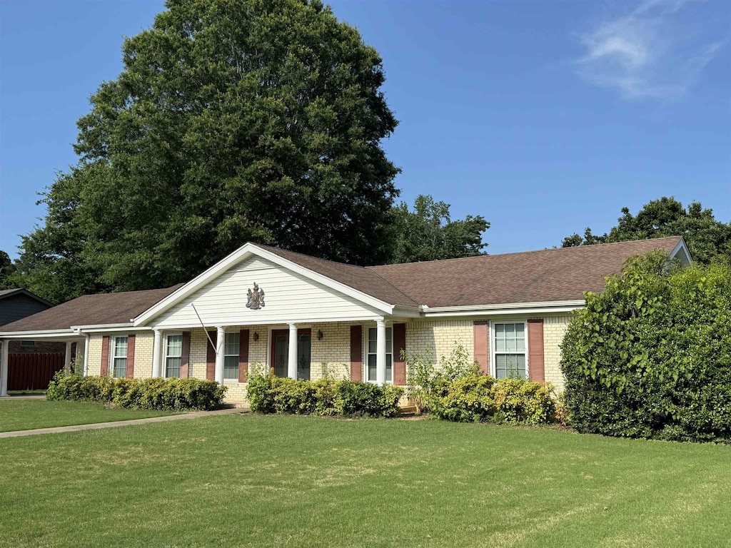  - ranch-style home featuring brick siding, a front yard, and a porch