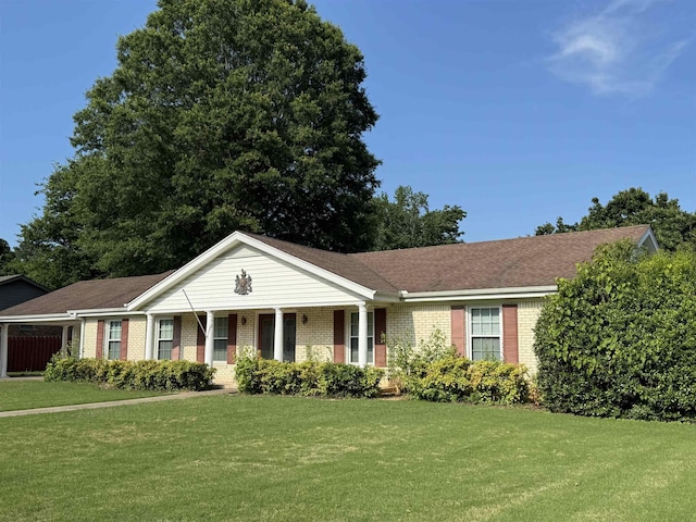  - ranch-style home featuring brick siding, a front yard, and a porch
