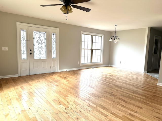 foyer entrance featuring ceiling fan with notable chandelier and light hardwood / wood-style flooring