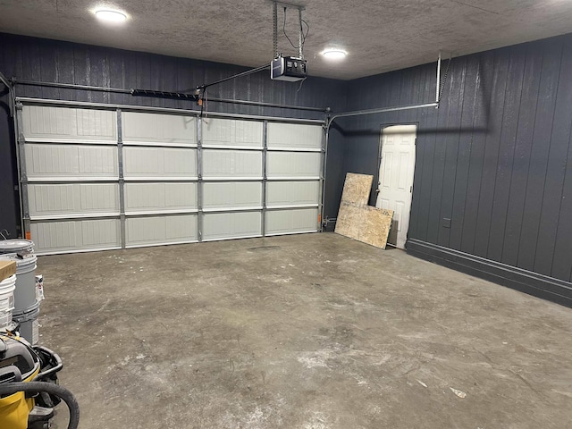 garage featuring wood walls and a garage door opener