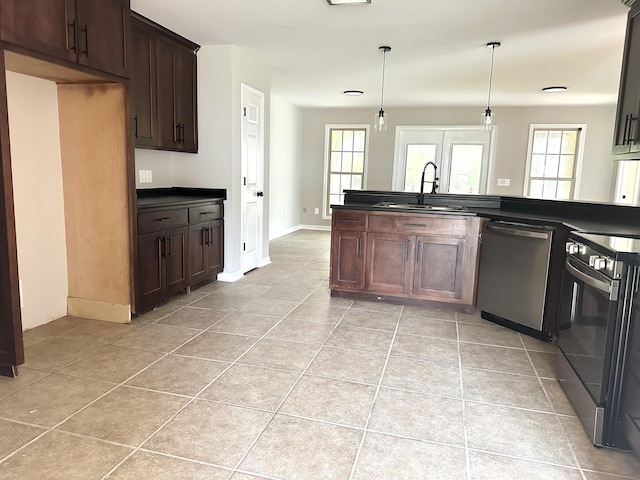 kitchen with dark brown cabinetry, sink, stainless steel appliances, decorative light fixtures, and light tile patterned flooring