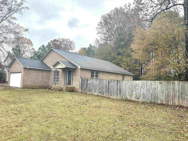 ranch-style home with a garage and a front lawn