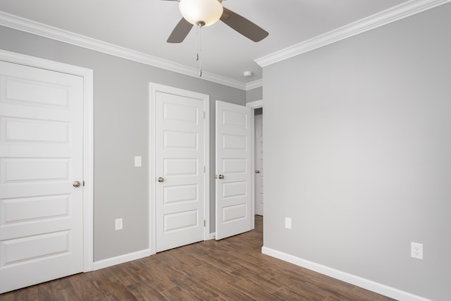 unfurnished bedroom featuring ceiling fan, baseboards, dark wood-style floors, and crown molding