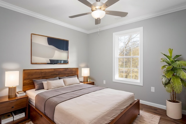 bedroom with a ceiling fan, crown molding, baseboards, and wood finished floors