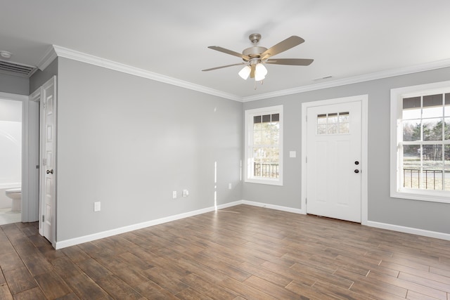 entryway with a wealth of natural light, visible vents, dark wood finished floors, and ornamental molding