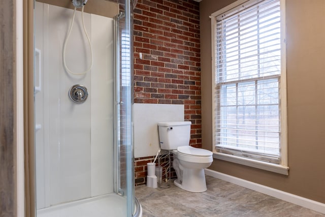 bathroom with brick wall, toilet, and a shower with door