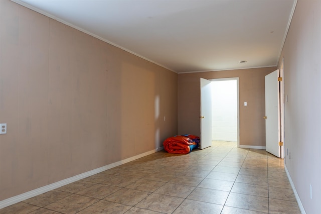 spare room featuring light tile patterned floors and ornamental molding