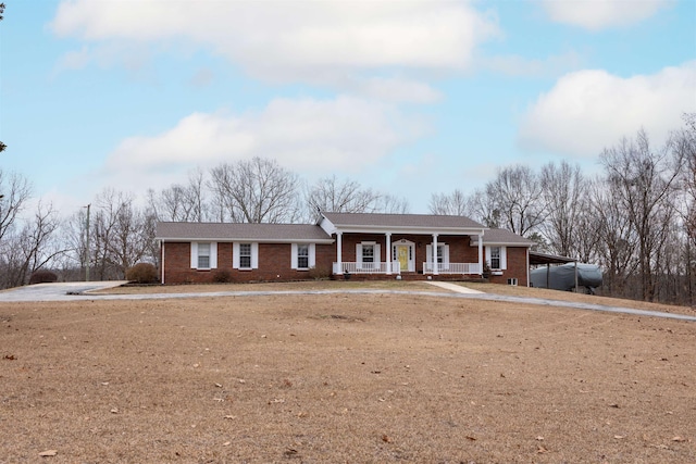 ranch-style home with a carport and covered porch