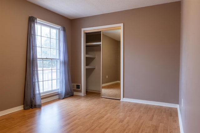 unfurnished bedroom featuring a closet and light hardwood / wood-style flooring