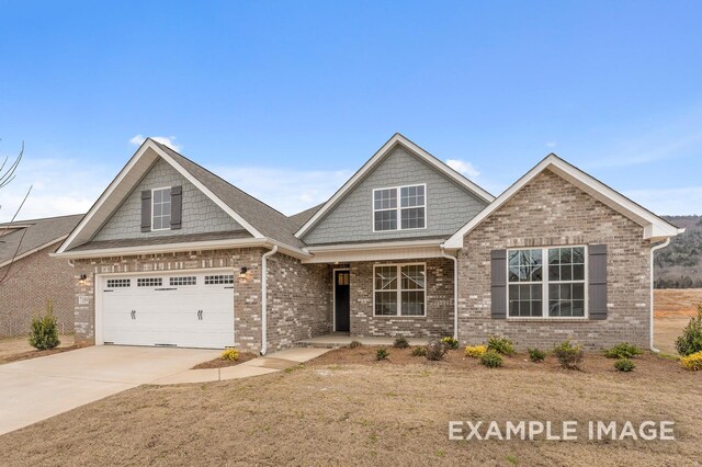 craftsman-style home featuring concrete driveway and brick siding