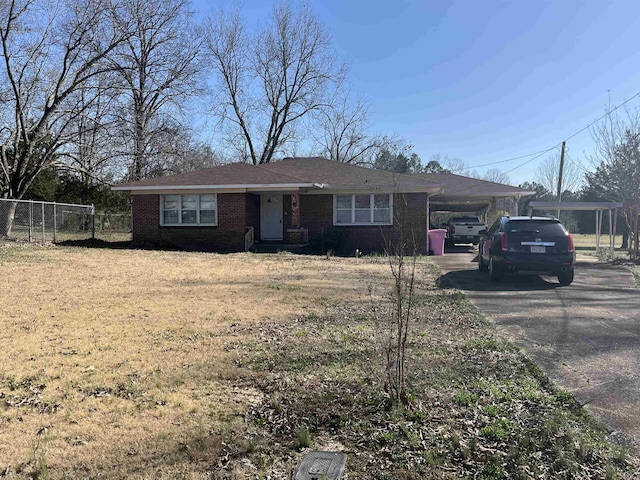 single story home with a carport, fence, brick siding, and driveway