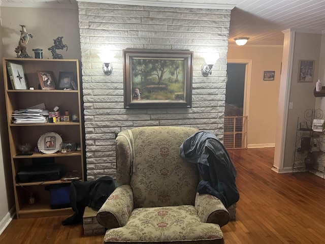 living area featuring baseboards, wood finished floors, and ornamental molding