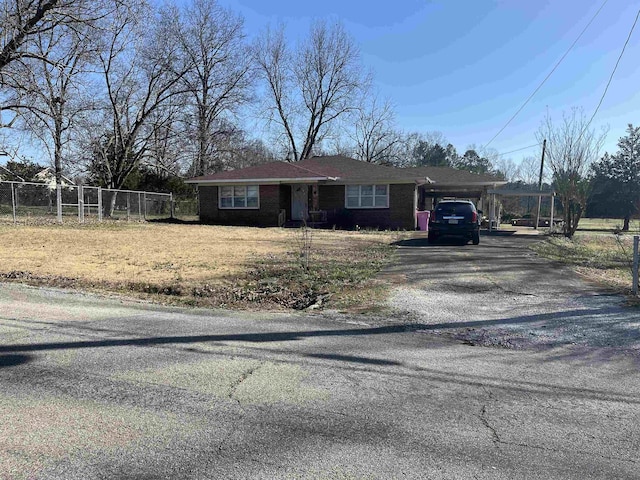 single story home with a carport, brick siding, driveway, and fence