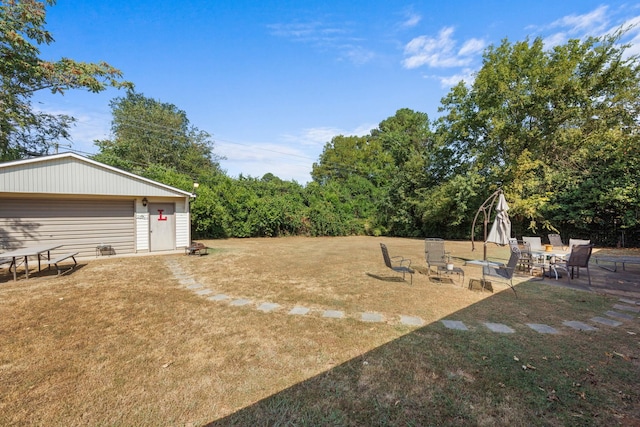 view of yard featuring a patio and an outdoor structure