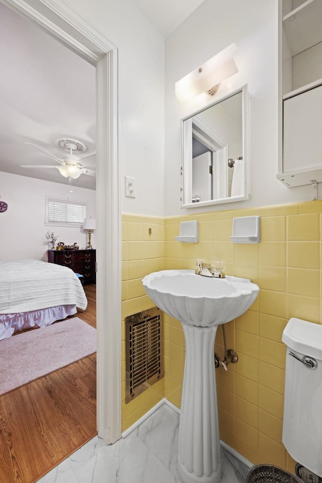 bathroom with tile walls and ceiling fan