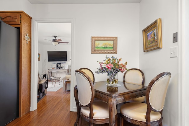 dining space with hardwood / wood-style flooring and ceiling fan