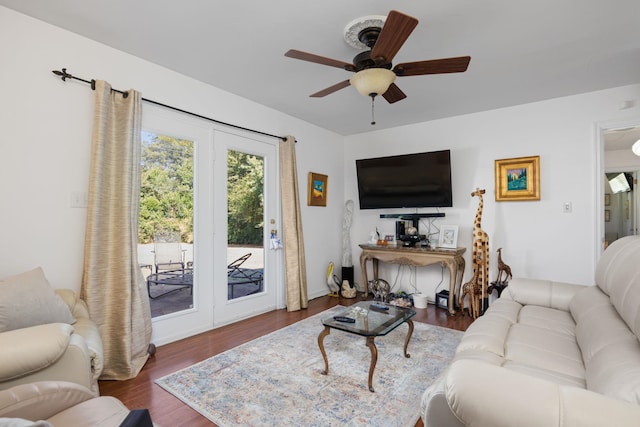 living room with ceiling fan and dark hardwood / wood-style flooring