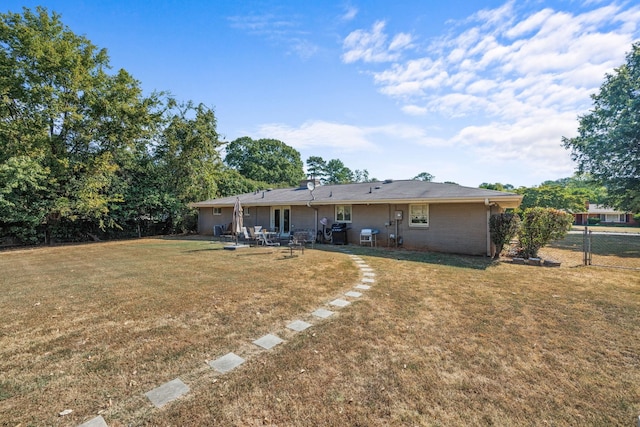 back of house featuring a lawn and a patio