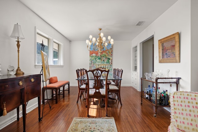 dining space featuring dark hardwood / wood-style flooring and a chandelier