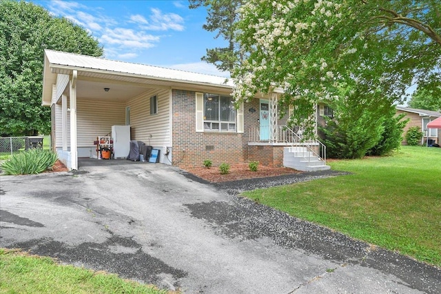  - view of front of house featuring driveway, metal roof, a carport, and brick siding