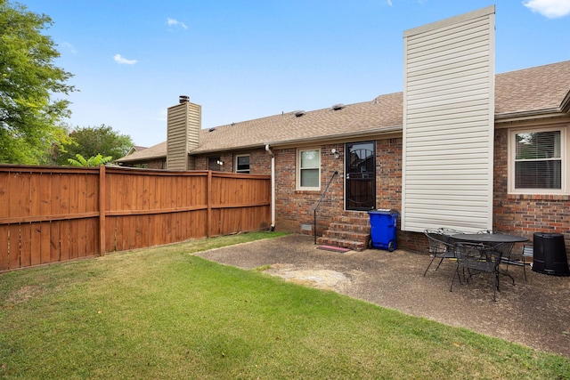 rear view of house featuring a patio and a lawn