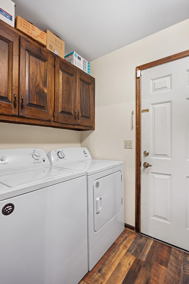 laundry room with washer and dryer, cabinets, and dark wood-type flooring