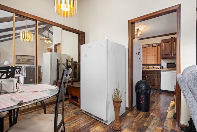 kitchen with decorative light fixtures, dark hardwood / wood-style flooring, white appliances, and ceiling fan with notable chandelier