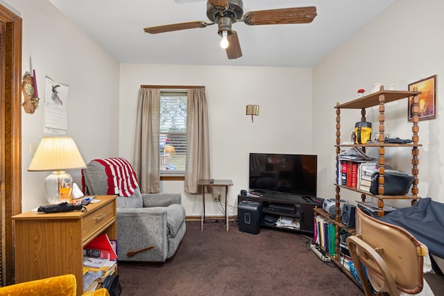 sitting room featuring ceiling fan and dark carpet