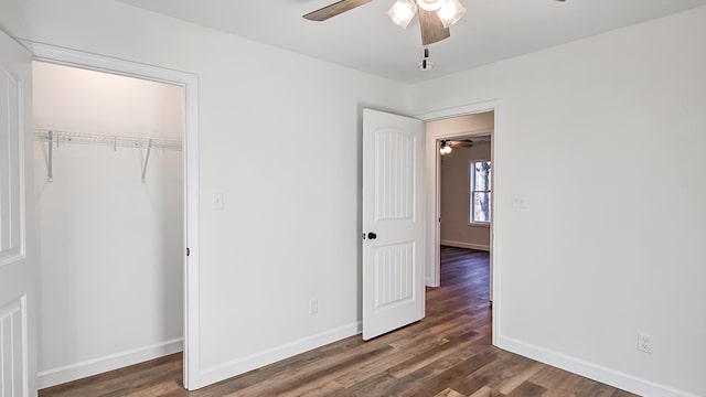 unfurnished bedroom featuring dark wood-type flooring, ceiling fan, and a closet