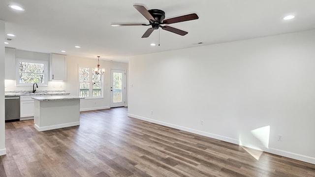 unfurnished living room with wood-type flooring, sink, and ceiling fan with notable chandelier