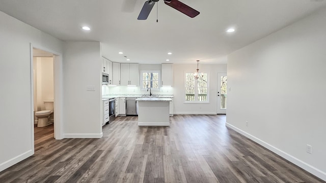 unfurnished living room with ceiling fan, dark hardwood / wood-style flooring, and sink