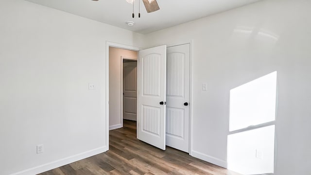 unfurnished bedroom featuring ceiling fan, dark hardwood / wood-style floors, and a closet