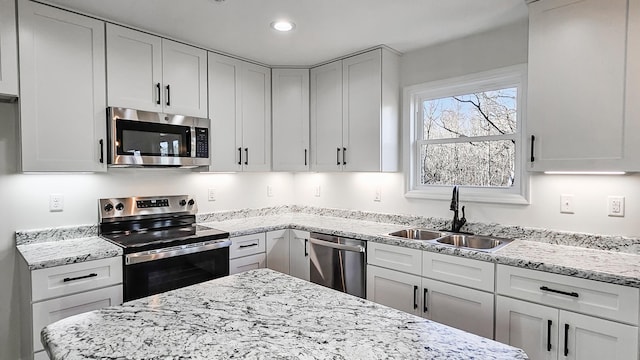 kitchen featuring stainless steel appliances, sink, and white cabinets