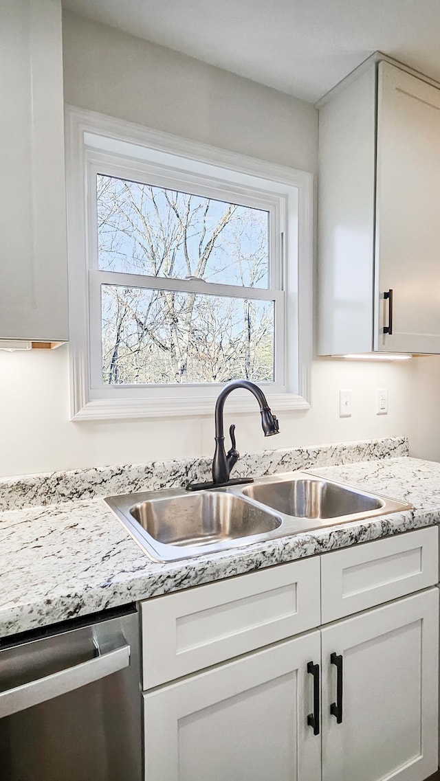 kitchen with white cabinets, sink, and dishwasher