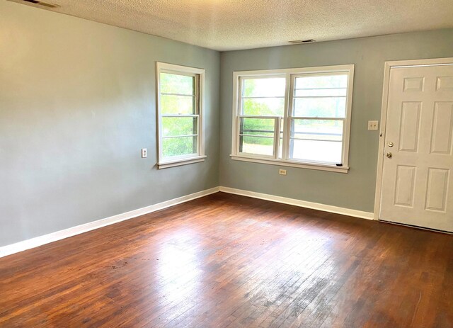  - unfurnished room with dark wood-style floors, baseboards, and a textured ceiling