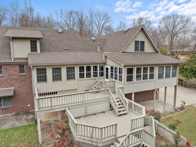 back of property featuring a wooden deck and a sunroom