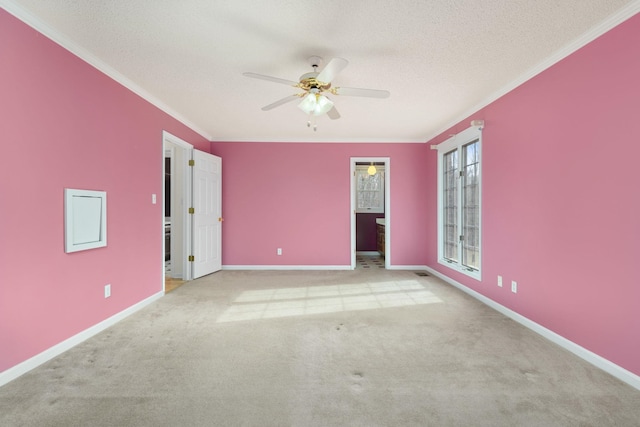 carpeted spare room with ceiling fan, ornamental molding, and a textured ceiling