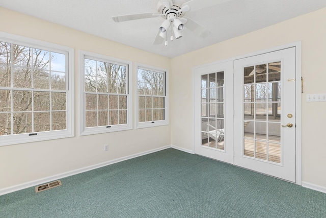 unfurnished sunroom featuring ceiling fan