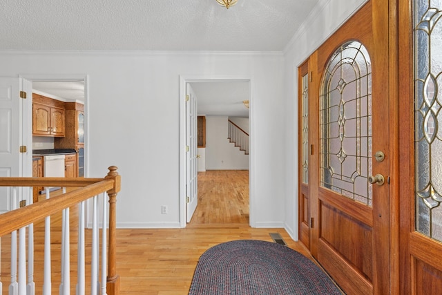 entrance foyer with crown molding, a textured ceiling, and light hardwood / wood-style flooring