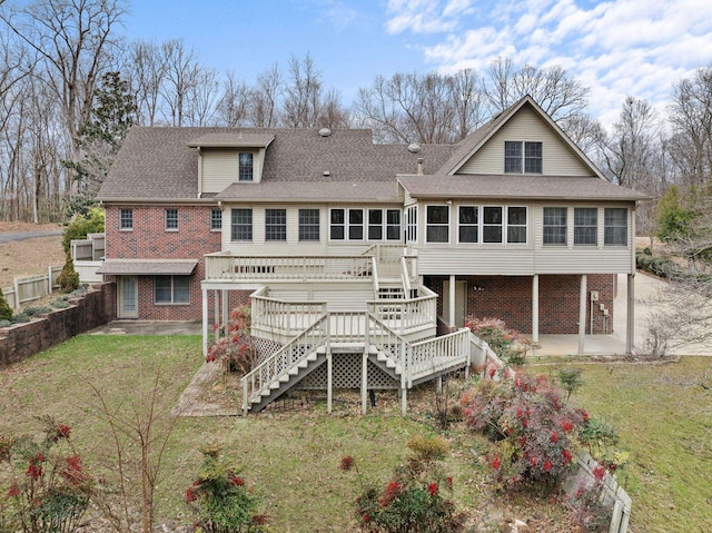 back of house featuring a sunroom, a deck, a patio area, and a lawn