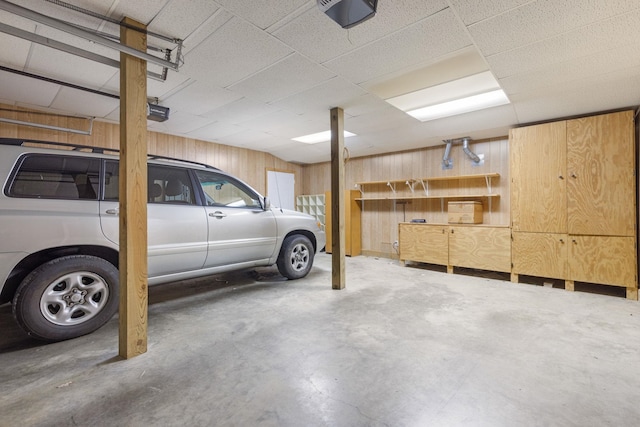 garage with a garage door opener and wooden walls