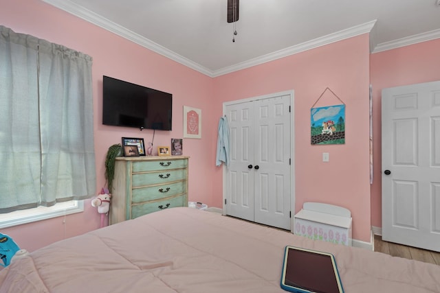 bedroom with ceiling fan, a closet, crown molding, and light wood-type flooring