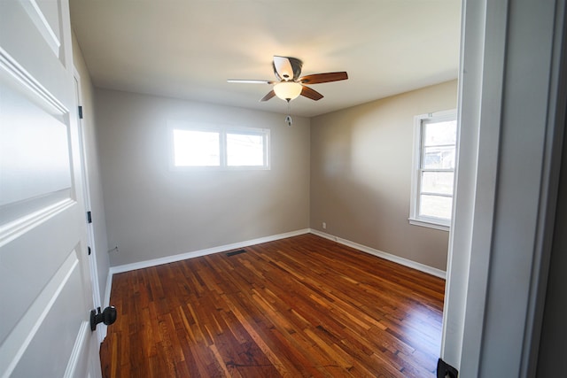 spare room featuring dark wood-type flooring and ceiling fan