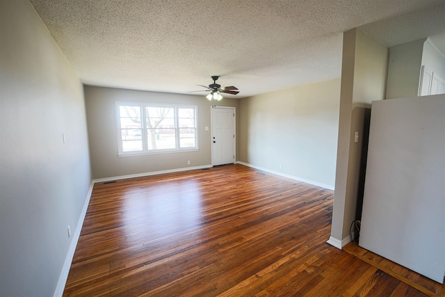 unfurnished room with ceiling fan, dark hardwood / wood-style flooring, and a textured ceiling