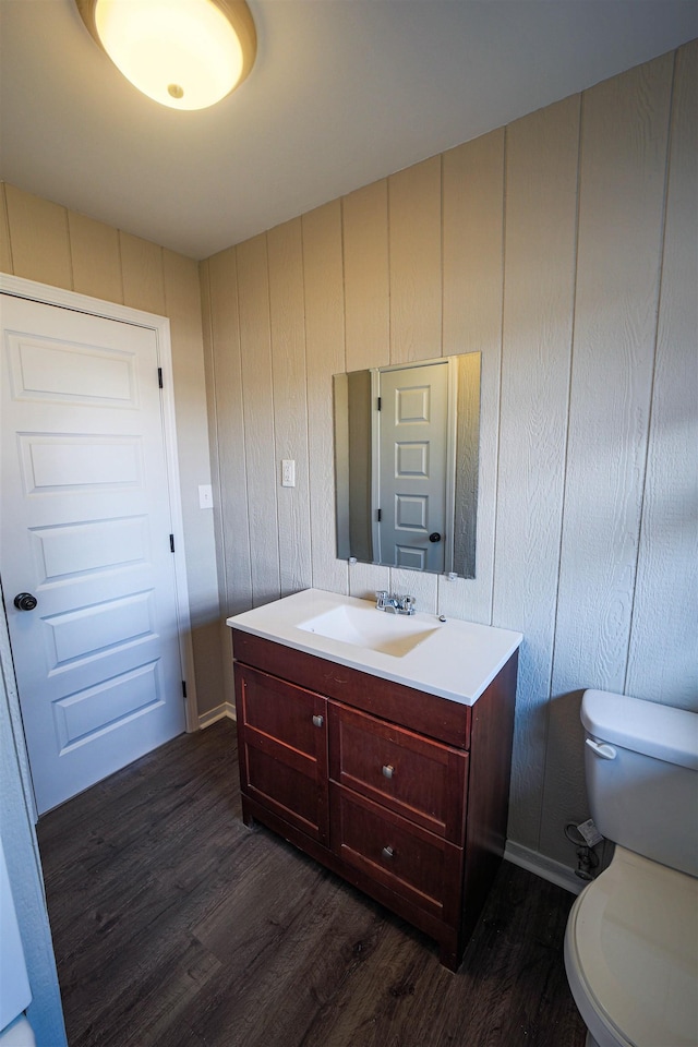 bathroom with hardwood / wood-style flooring, vanity, and toilet