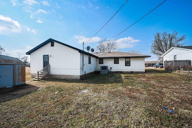 back of property featuring cooling unit and a lawn