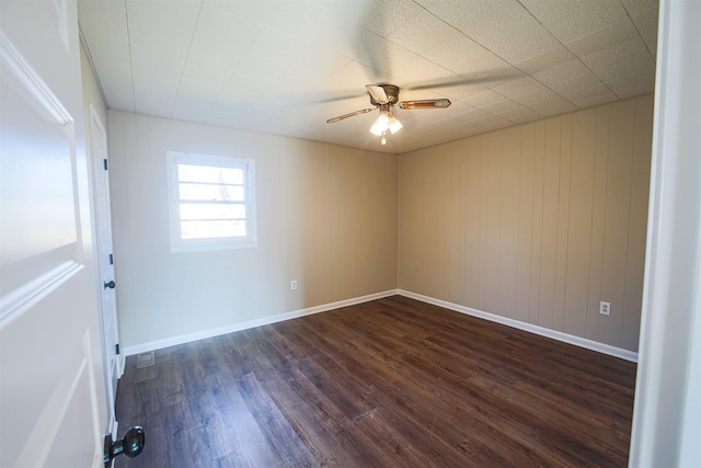 spare room featuring dark wood-type flooring and ceiling fan