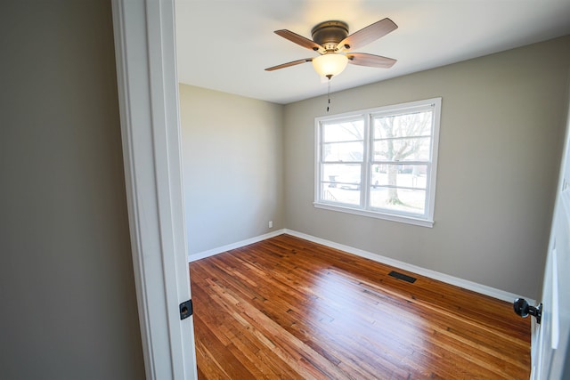 spare room with hardwood / wood-style flooring and ceiling fan