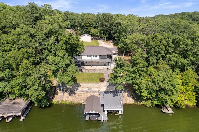 drone / aerial view featuring a water view and a wooded view